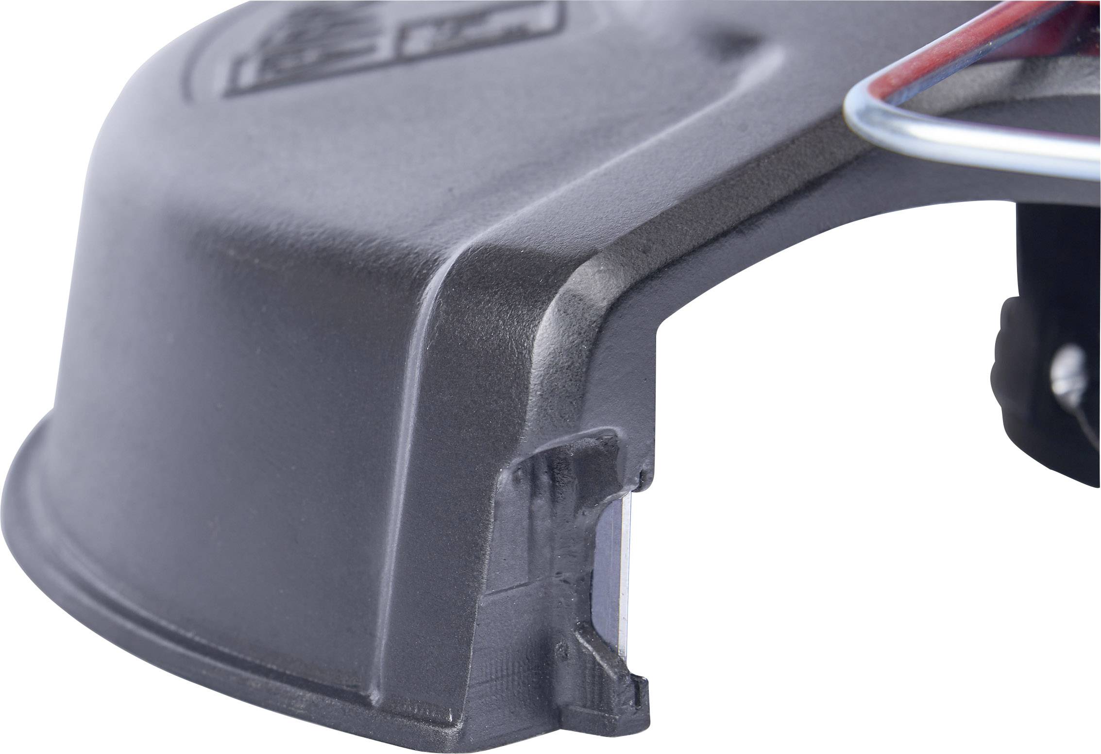 Close-up of part of a black plastic casing with a small aperture and a wire detail.