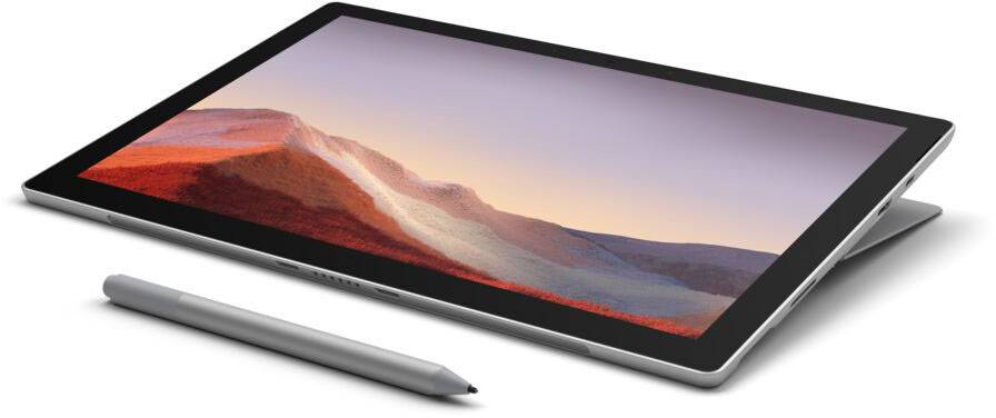 A tablet with a detachable keyboard and stylus pen lies at an angle on a table. A mountain landscape is visible on the screen.