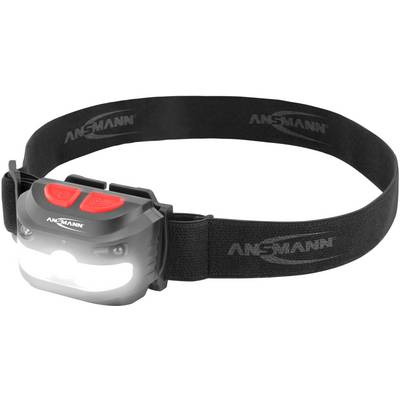Black head torch with adjustable strap and two red buttons. Bright light shines from the front. 'Ansmann' marking visible.