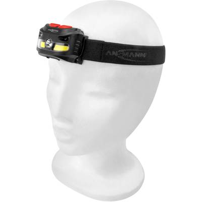 White mannequin with a black head torch on an elastic band. Head torch with red and yellow components and brand lettering.