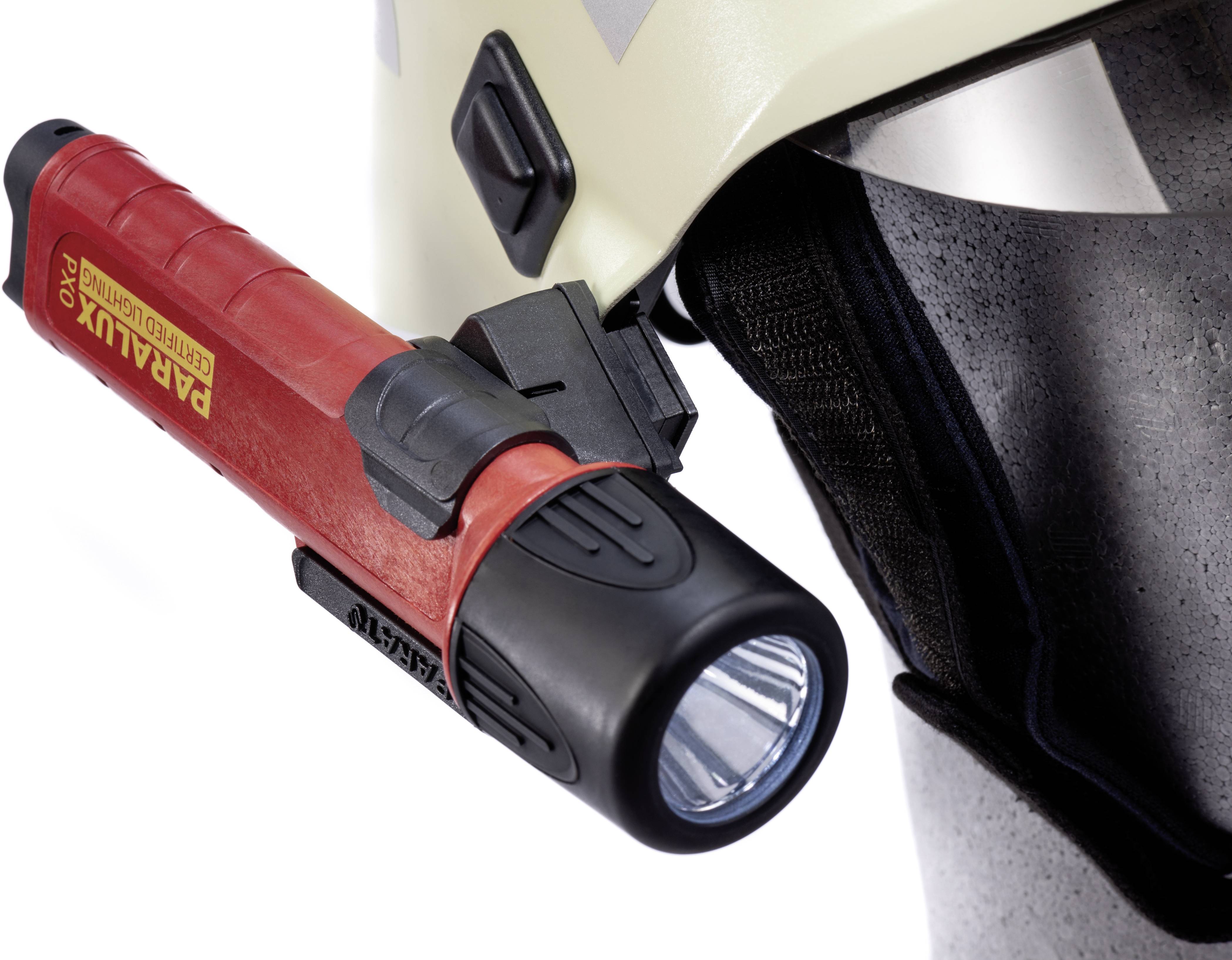 A red torch is attached laterally to a white helmet. It is robustly constructed and designed for use on helmets.