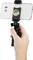 A hand is holding a selfie stick with a smartphone displaying a photo of two people.
