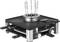 An electric fondue set with a stainless steel frame and multiple forks, positioned on a black base with control knobs.