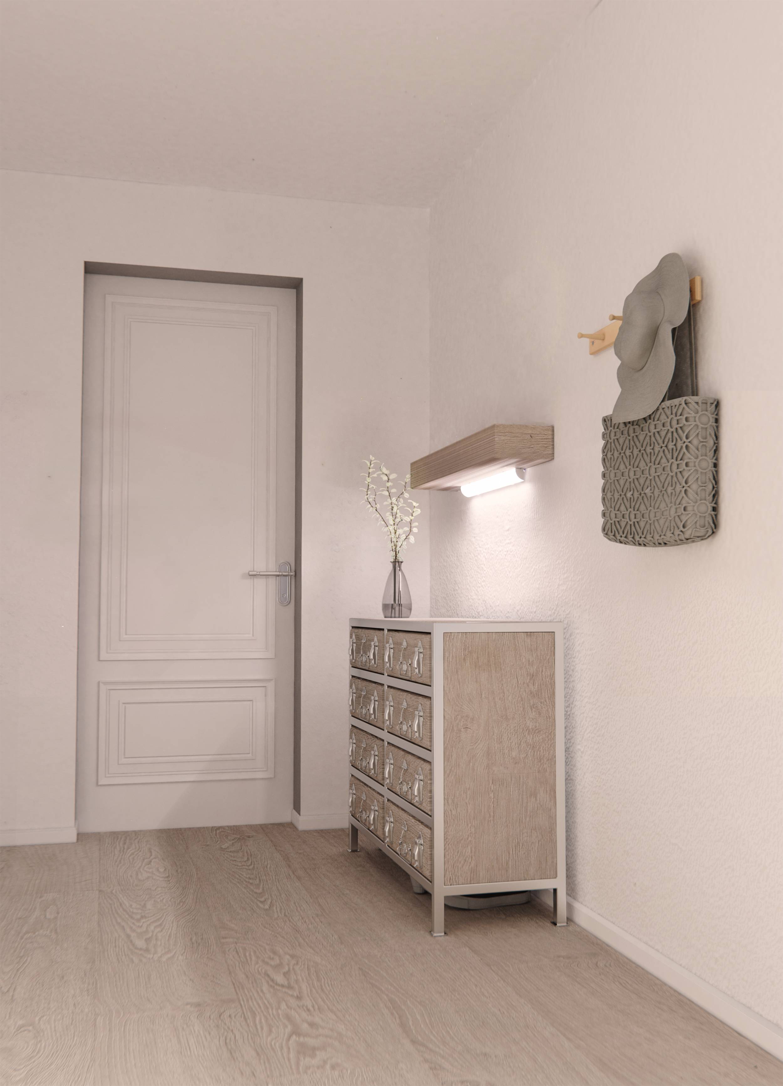 Modern, bright entrance hall with a white door, wooden flooring, chest of drawers, decorative lamp, and wall-mounted bag with a hat.