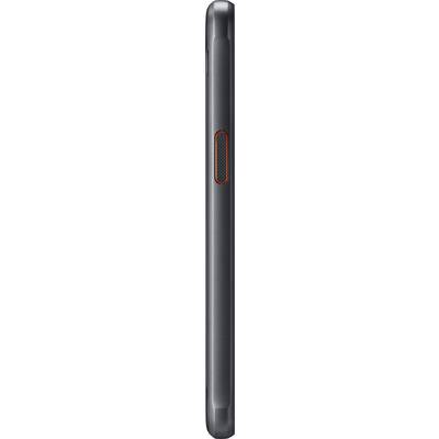 A side view of a black mobile phone with a red button in the centre.