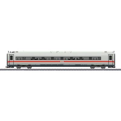 A grey railway carriage with red stripes is standing on tracks. Windows are evenly distributed, numbers indicate seat classes.