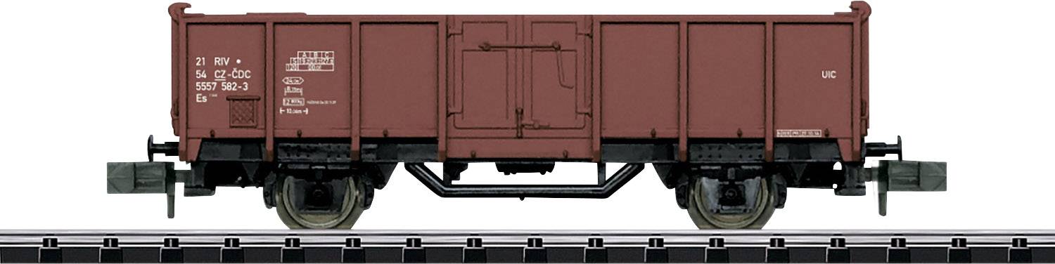 A brown goods wagon on a railway track. The wagon has stacked planks and metal wheels. There are technical inscriptions on the side.