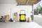 A well-organized garage with a yellow floor sweeper, tools, and a bicycle neatly arranged against the wall; open garage door shows driveway.