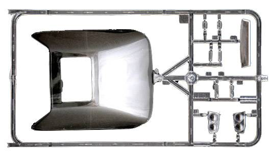 A die-cast frame with parts of a model vehicle. The main component is a body-like form, surrounded by smaller components.