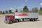A red articulated lorry with the inscription 'Intercontinental Express' on the silver trailer is parked on a gravel area.