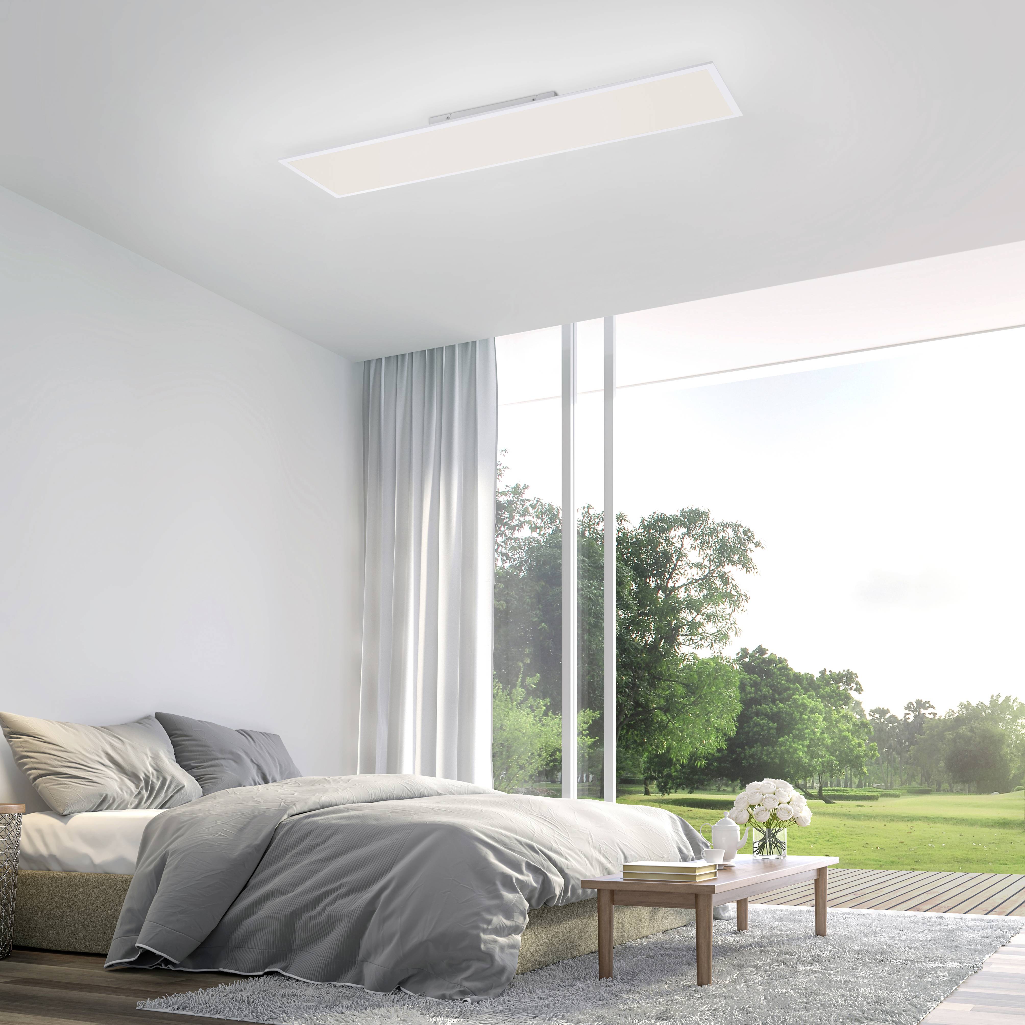 Bedroom with a large bed, white walls, large windows overlooking a green garden, and a modern ceiling light.