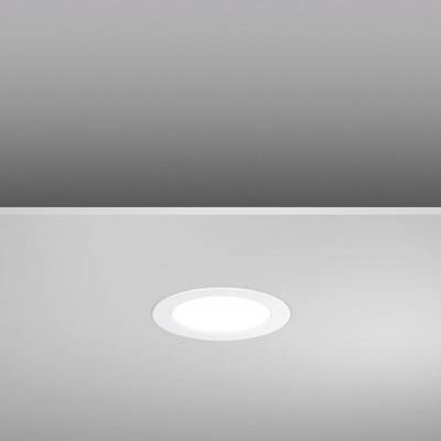 Round ceiling light in a room with grey walls. The lamp is switched on and emits bright, neutral light.