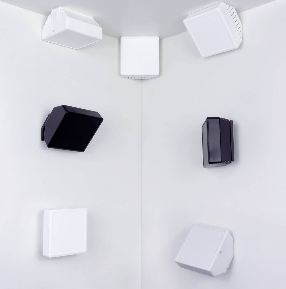 Six cube-shaped speakers in white and black are arranged at the corner of a white wall.