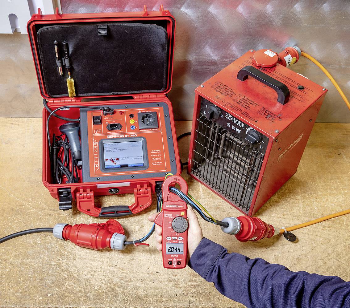A device is checking the electrical voltage of a cable, displayed as '204 V' on a handheld measuring instrument. Test and charging equipment can be seen in the background.