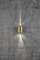 A golden wall light on a concrete wall radiates light upwards and downwards, creating symmetrical light cones.