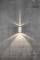 Wall light on concrete wall, casting light upwards and downwards, creating subtle light cones.