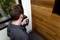 A man is using an infrared thermometer to measure the temperature of a wooden wall section next to a window.