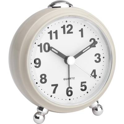 A round, cream-coloured alarm clock with a dial shows 10:10. The clock has silver hands and stands on two small feet.