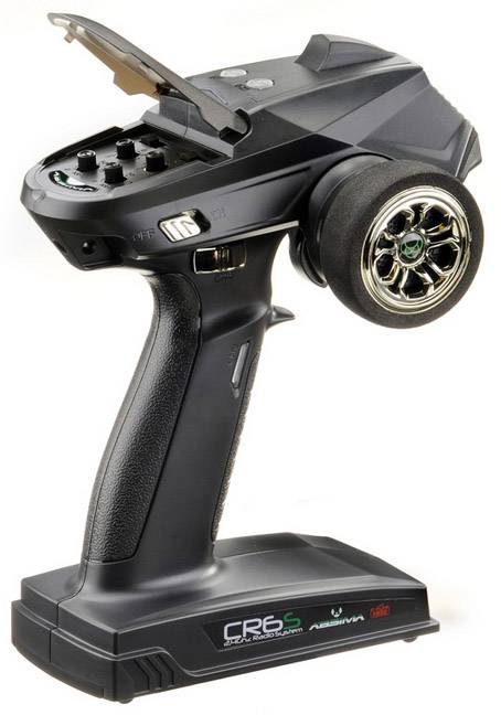 A black radio remote control for RC cars with a trigger grip and a steering wheel on a white surface.