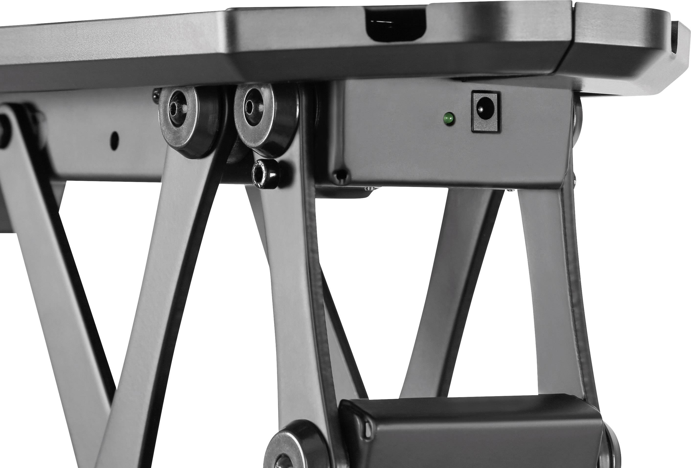 Electrically adjustable desk frame in close-up with a black metal frame and a green control light in the centre.