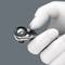 A white, right-handed tactical grip holds a silver multi-tool kit at its torque adjustment dial.