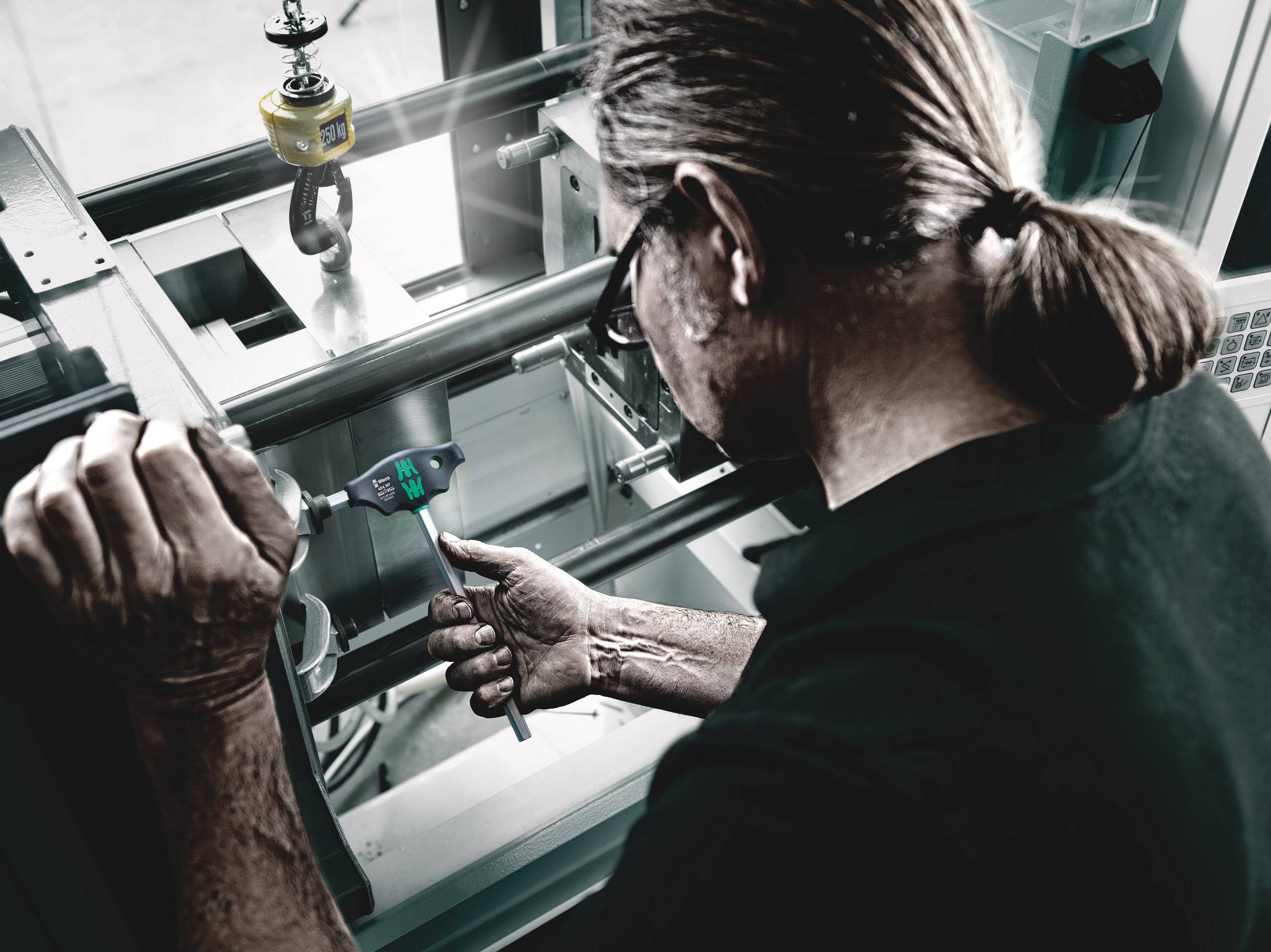 A person is precisely measuring a metal component with a digital vernier calliper calibration in an industrial environment.