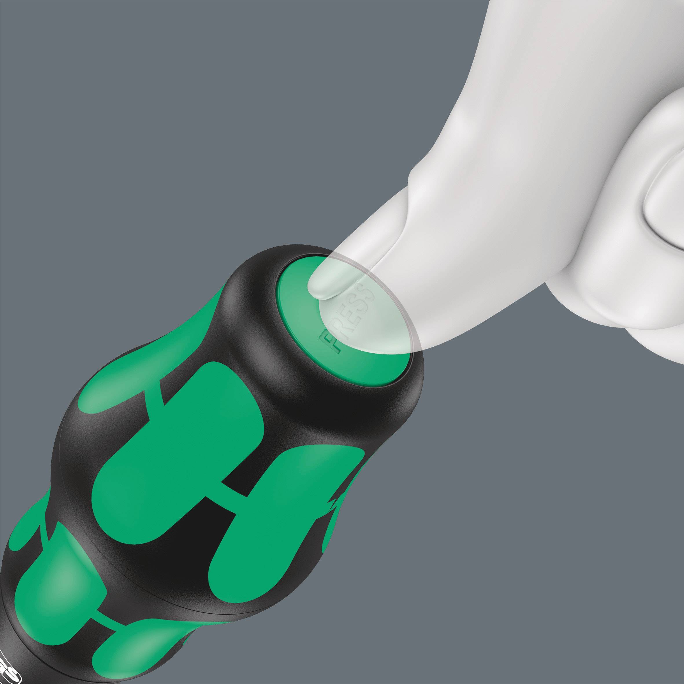 A hand is pressing the end cap of a screwdriver with a green and black handle to demonstrate the pressure point.