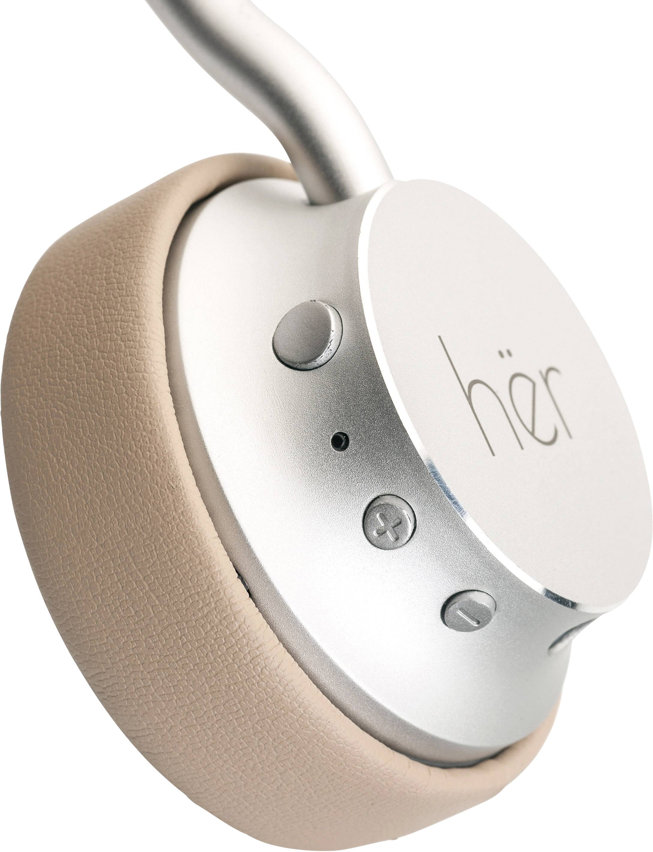 Headphones with beige ear cushions and a silver headband, with controls located on the side.