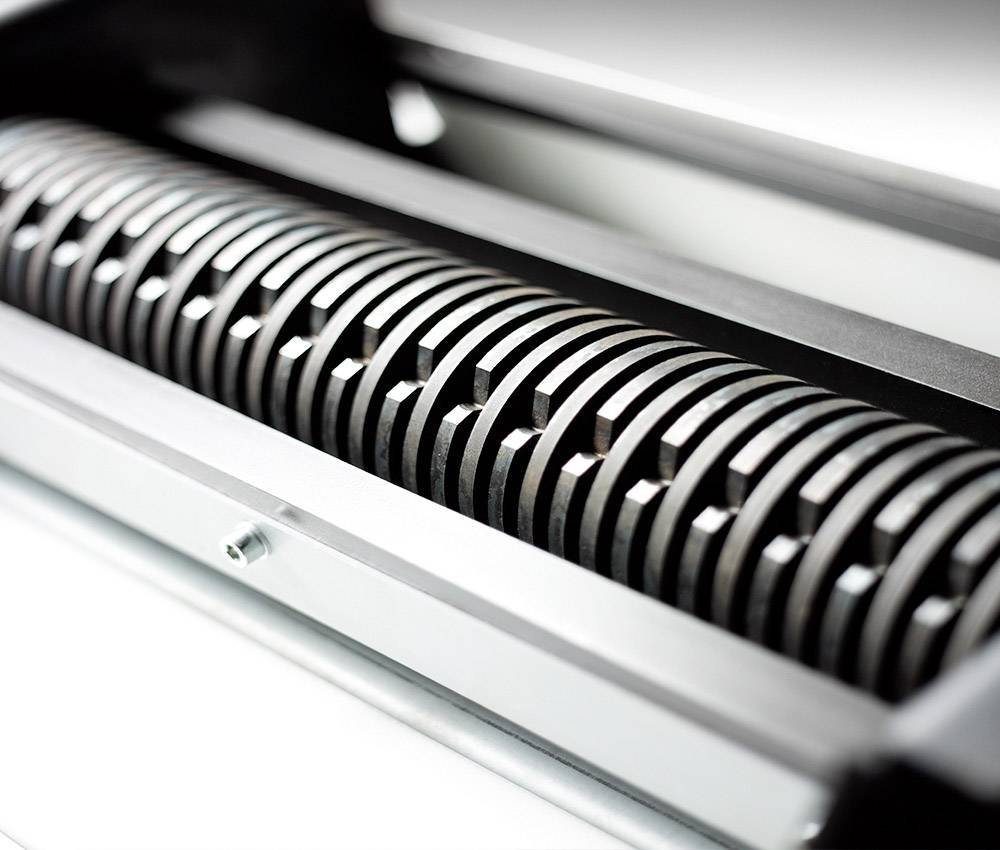 Close-up of a toothed metal cylinder in a machine, possibly part of a printing or rolling system.