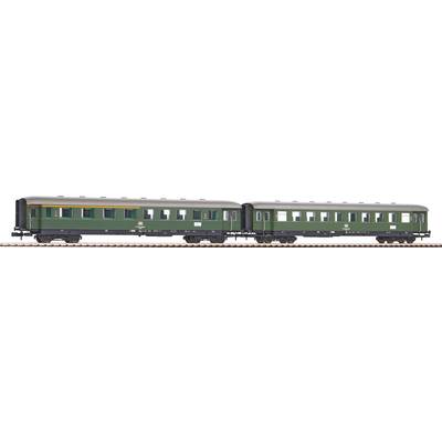 Two green railway carriages on a section of track, viewed from the side. They have black chassis and multiple windows.