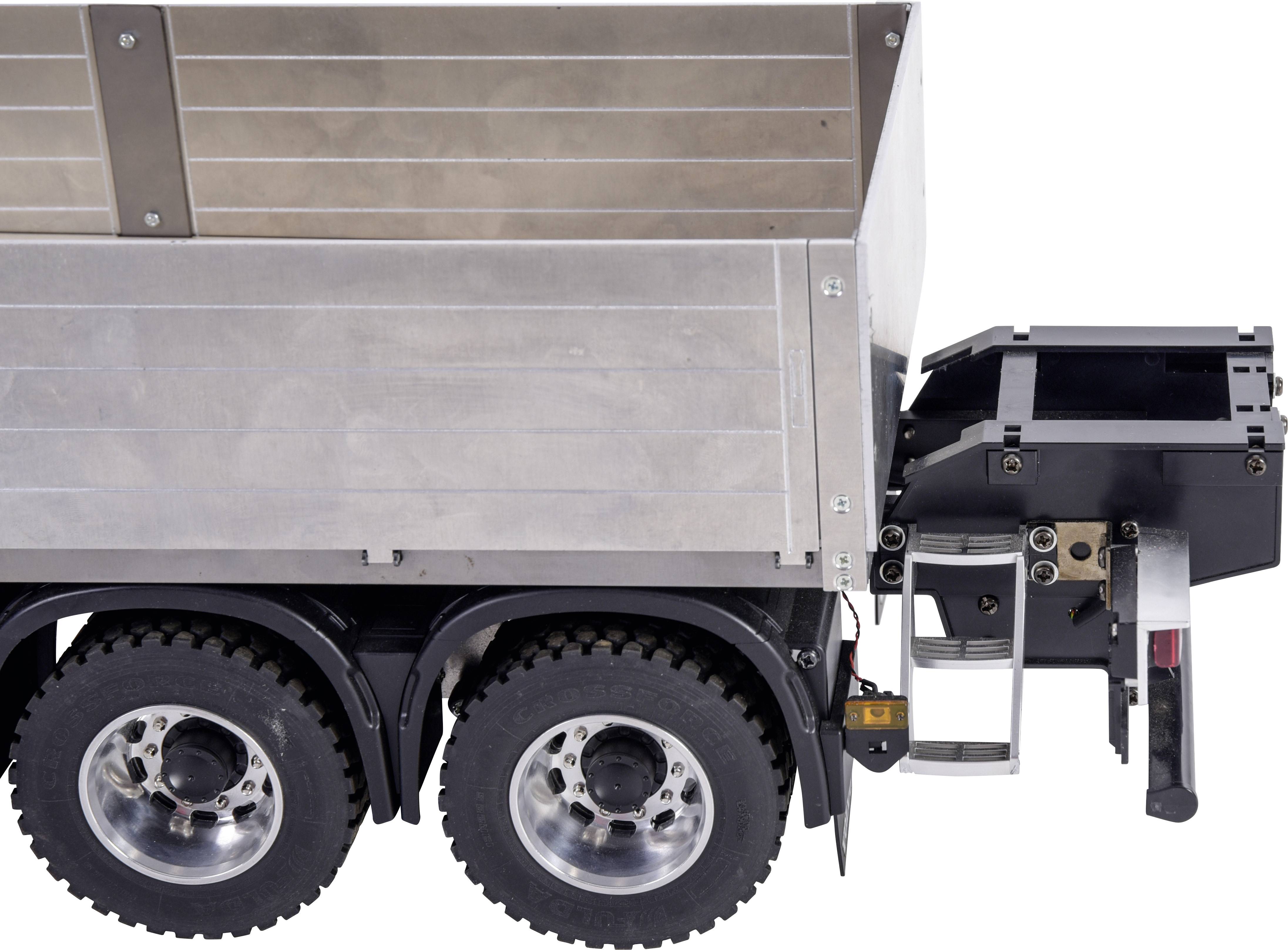 Trailer with two axles and double-sided loading flaps, folded compactly. Various fastenings and hooks visible on the rear side.
