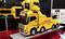 A yellow model of a recovery truck with 'Hall's Truck Rescue' lettering is standing on an exhibition stand, surrounded by information posters.