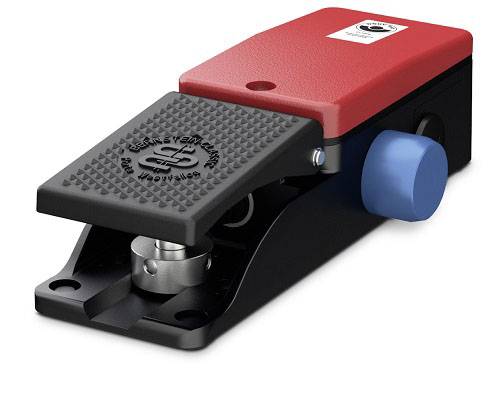 An industrial foot switch with a red casing, black pedal, and blue button, used for controlling machinery.