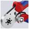 A close-up image of a crimping tool with red and blue handles, featuring a circular metal crimping mechanism and an adjustable knob.