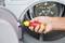 'Close-up of a person tightening a screw with a screwdriver in the door opening of a tumble dryer.'