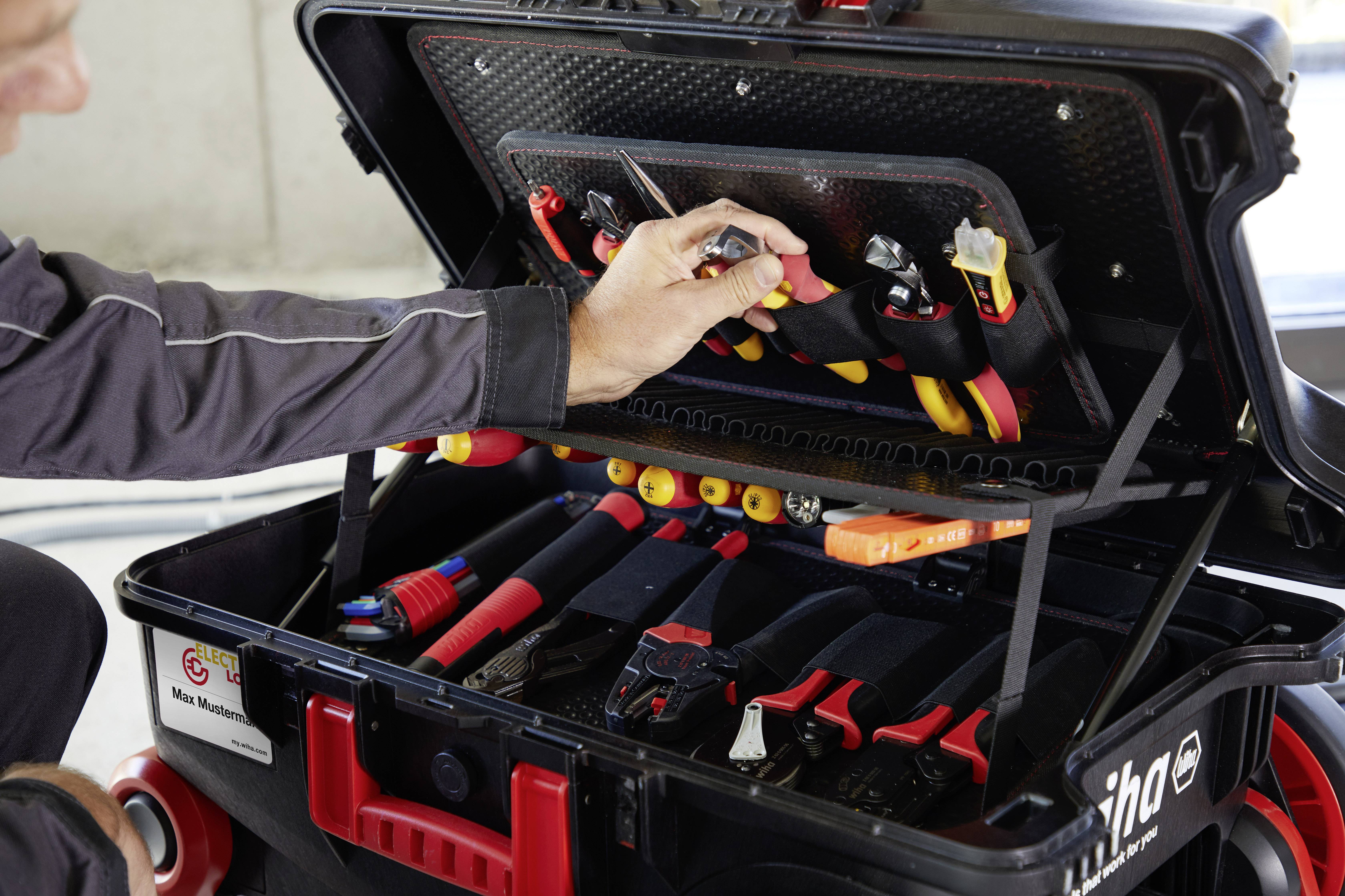 A person opens a tool case. Inside the case are various tools such as screwdrivers and pliers.
