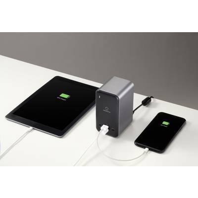 A tablet and smartphone on a table, both displaying charging screens and connected to a power bank.