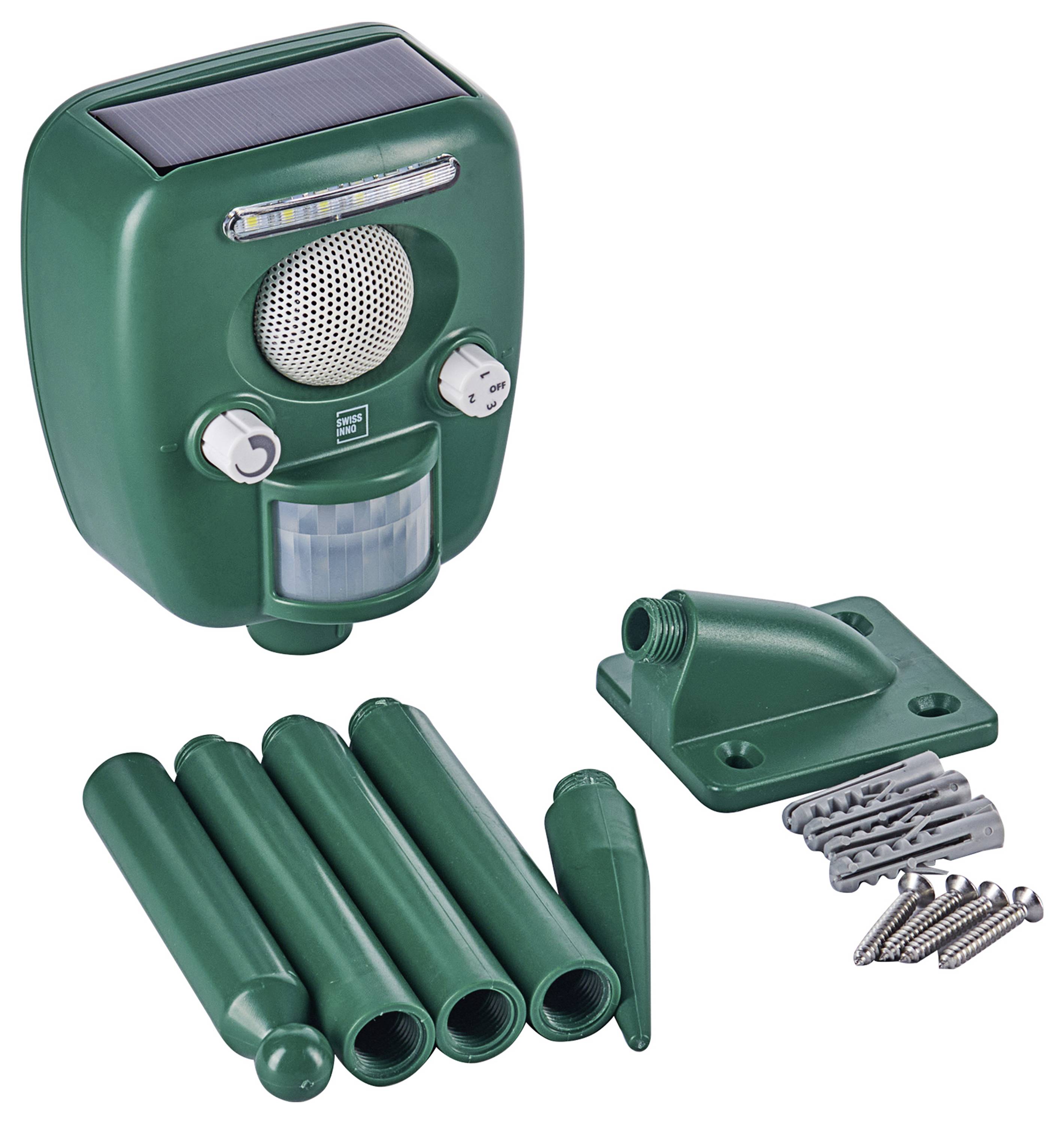 A green solar-powered animal repeller with a speaker, motion sensor, mounting base, stakes, and screws, designed for outdoor use.