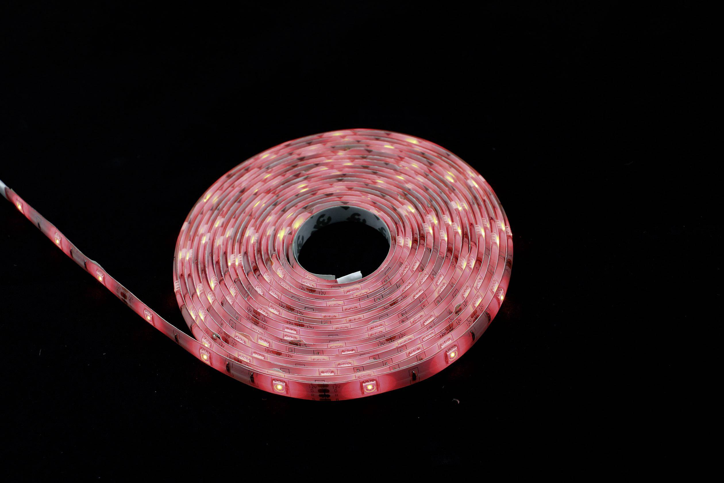 A rolled-up, illuminated red LED light strip on a black background, demonstrating flexible form and uniform light distribution.