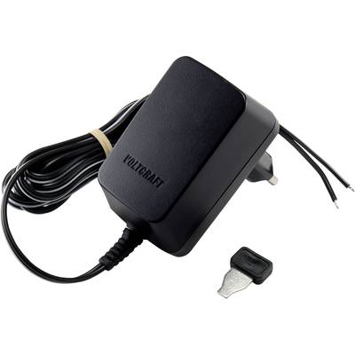 A black Voltcraft power supply with exposed wire ends lies next to a metal attachment, presumably an adapter.