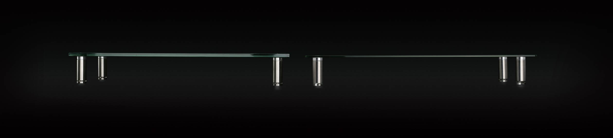 A modern design shelving unit with two glass shelves supported by metal stands, pictured side-on against a black background.