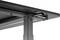 A black metal table with an adjustable leg, close-up of the underside showing screws and a cylindrical lever for height adjustment.
