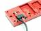 Red plug system connected with two cables to a rectangular module used for industrial or technical applications.