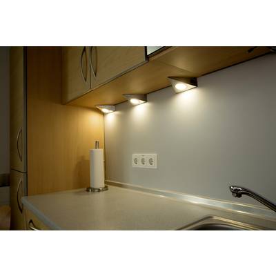 Kitchen with illuminated work area; roof lights shine on grey worktop and sockets, paper towel holder on the left.