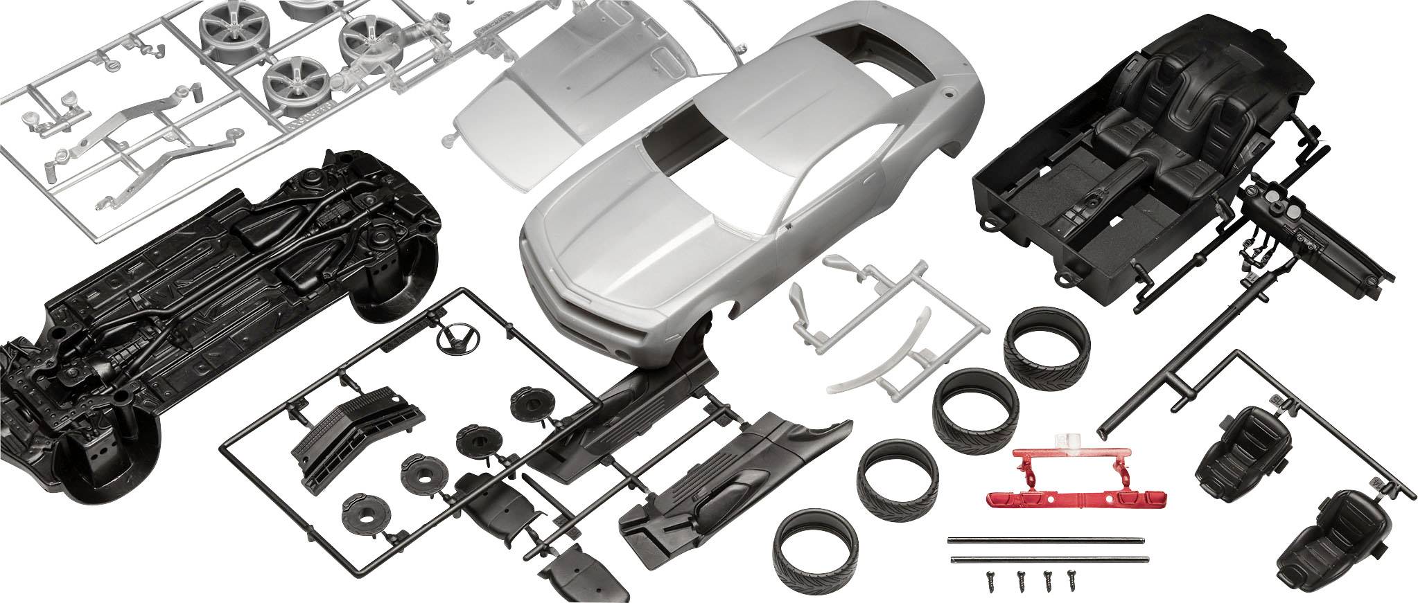 Parts of a model car kit: Body, wheels, chassis and accessories made of plastic, laid out before assembly on a white surface.
