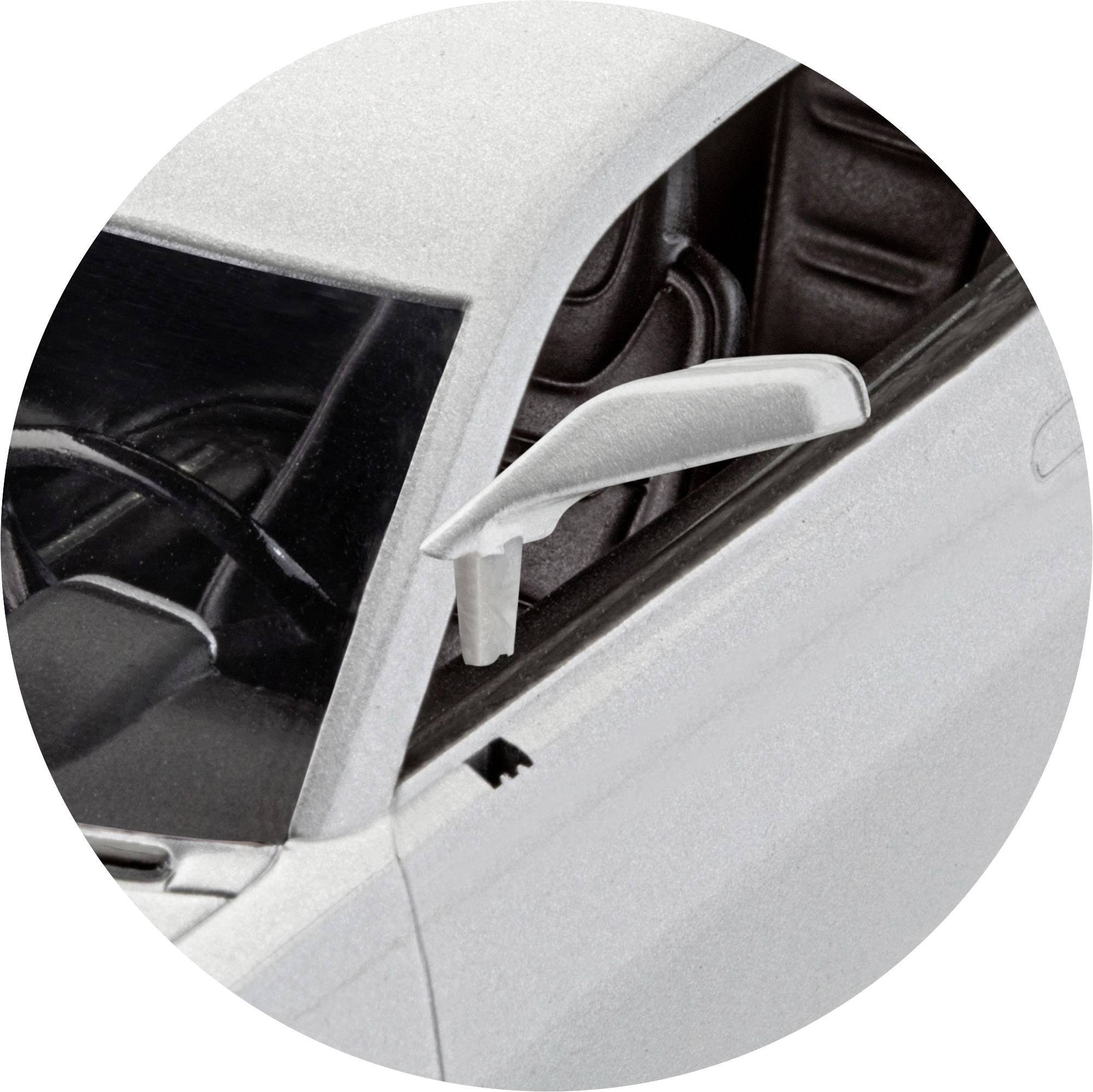 Close-up of a white car focusing on the wing mirror, with the driver's door open revealing the vehicle's interior.