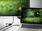 A laptop is connected to a monitor via an HDMI cable. Both screens are displaying a similarly blurry image of grass and flowers.