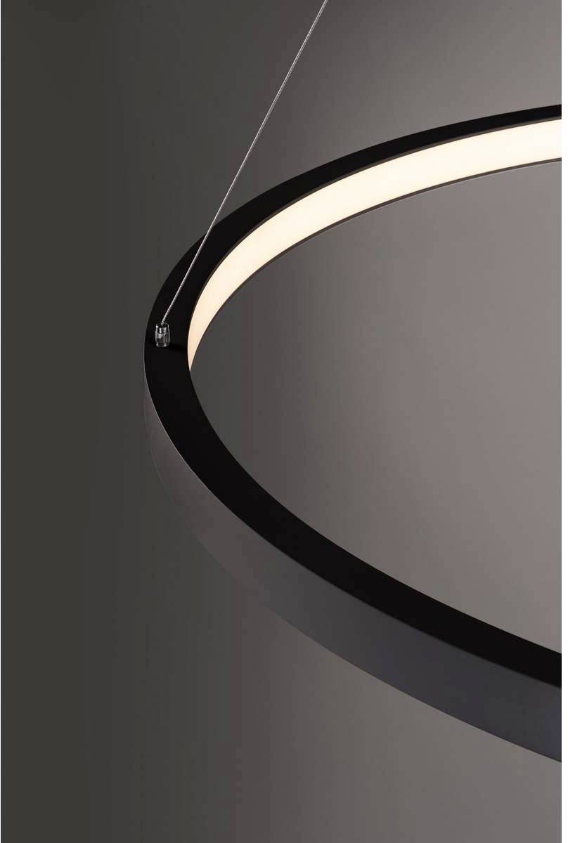 A contemporary, round pendant light with a black rim and soft, uniform light, hangs against a grey background.