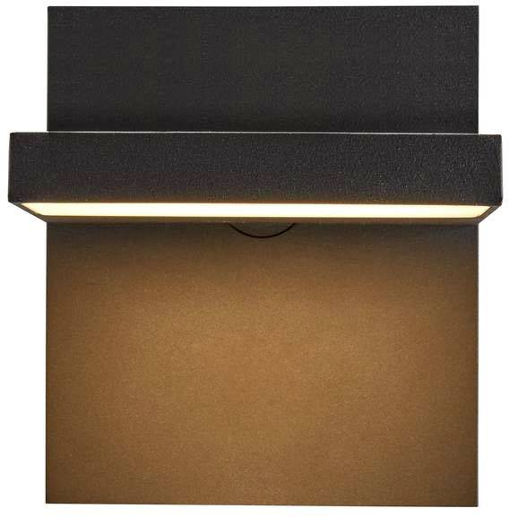 A rectangular, black wall light with illumination that shines down onto the surface beneath it.