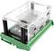 A transparent Perspex box with a green base containing electronic components.<br><br>Note: In British English, "Plexiglas" is typically referred to as "Perspex", which is the more commonly used term in the UK.